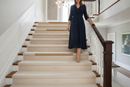uPVC wood effect stair nosing in Noble Oak — real-life installation on UK staircase with person using the stairs