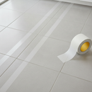Clear transparent anti-slip tape on ceramic floor tiles — virtually invisible grip protection