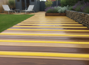 Yellow GRP non-slip strips on garden decking boards — permanent outdoor anti-slip protection