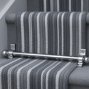 Polished chrome stair rods fitted on grey and white striped runner — high-end contemporary interior