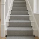 Black stair rods with ball finials on grey herringbone stair runner — modern UK home