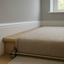 Bronze stair rods securing grey carpet runner on modern UK home staircase