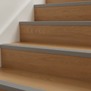 Grey self-adhesive PVC stair nosing installed on wooden stairs in modern UK home