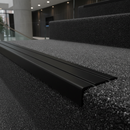 Matt Black NAS stair nosing on dark carpet staircase in modern UK commercial building