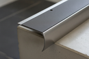 Close-up of anti-slip bullnose stair nosing showing semi-rounded curve and permanently bonded PVC insert at step nose