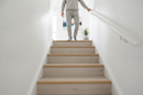 uPVC wood effect stair nosing in Beech — real-life installation on UK staircase with person using the stairs