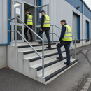 Black GRP anti-slip stair nosing on concrete steps at UK warehouse industrial entrance