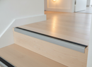 Anodised aluminium screw-fix stair nosing installed on wooden staircase in UK home hallway