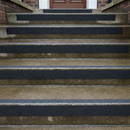 Black anti-slip tape on wet outdoor concrete steps — waterproof grip tape for external use