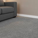 White flexible skirting board trim running along living room wall meeting carpet