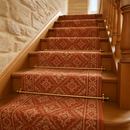 Satin brass plain stair rods with ball finials on British country house staircase with terracotta runner
