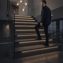 Heavy duty tile-in stair nosing in Midnight Grey — real-life installation with person using tiled UK staircase