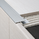 Close-up of tile-in aluminium stair nosing profile installed flush with tiles at a step edge