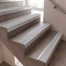 Light gray metal stair rails installed on concrete steps next to a wall with a metal handrail.