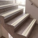 White step strips installed on a set of concrete stairs in a home interior.