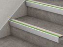 Beige and green slimline insert stair nosings fitted to two grey concrete-effect steps