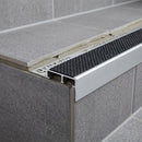 Aluminium tile-in stair nosing with black anti-slip insert on grey tiled step
