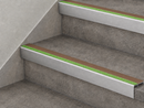 Brown and green slimline insert stair nosings fitted to two grey concrete-effect steps