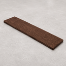 Brown non-slip insert strip lying flat on a pale grey concrete surface