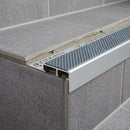 Aluminium tile-in stair nosing with dolphin grey anti-slip insert on grey tiled step
