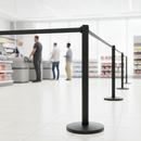 Row of black retractable belt barrier stanchions forming a queue lane in a busy retail store checkout area