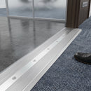 Screw-fit aluminium cover strip 100mm spanning a floor transition joint