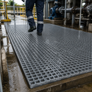 Grey GRP anti-slip fibreglass grating panel at wet industrial water treatment plant