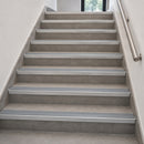 A set of modern gray stair steps with silver metal handrails on both sides, shown in a clean interior setting.