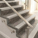 Mill finish aluminium raked back nosings on mottled stone steps between stainless handrails