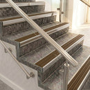 Raked back nosings with olive brown ribbed inserts on mottled stone steps between stainless handrails