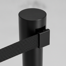 Close-up of the retractable belt cassette and locking belt end on a black queue barrier stanchion post