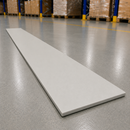 A long, thin rectangular white board or tile lies diagonally on a polished gray warehouse floor, with pallets and shelving visible in the blurred background.