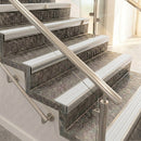 Raked back nosings with polar grey ribbed inserts on mottled stone steps, viewed along the flight