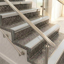 Raked back nosings with smooth polar grey inserts on mottled stone steps between stainless handrails