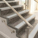 Raked back nosings with smooth polar grey inserts on mottled stone steps between stainless handrails