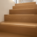 Oak finish NAS aluminium self-adhesive stair nosing installed on oak laminate staircase in modern UK home