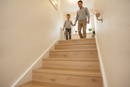 uPVC wood effect stair nosing in Light Oak — real-life installation on UK staircase with person using the stairs