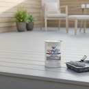 Light grey anti-slip decking paint freshly applied to a garden timber deck with a paint roller and tin resting on the boards