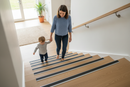 Anti-slip aluminium stair nosing ramp profile installed on laminate UK home staircase with family using the stairs safely