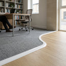 White flexible PVC beading trim creating smooth transition between wood flooring and grey carpet in modern office