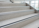 Silver aluminium stair nosing installed across commercial stone staircase steps