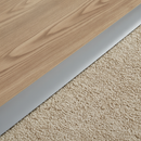 Close-up of self-adhesive PVC floor strip installed flush between two floor types