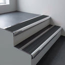 Polished aluminium bullnose stair nosing 66.5x30mm with Black Castellated insert fitted on an office stair