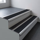 Mill aluminium bullnose stair nosing 66.5x30mm with Black Smooth Textured insert fitted on an office stair
