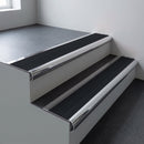 Polished aluminium bullnose stair nosing 66.5x30mm with Black Smooth Textured insert fitted on an office stair