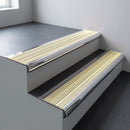 Polished aluminium bullnose stair nosing 66.5x30mm with Ivory Castellated insert fitted on an office stair