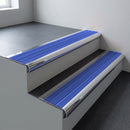 Polished aluminium bullnose stair nosing 66.5x30mm with Mid Blue Castellated insert fitted on an office stair