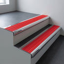 Polished aluminium bullnose stair nosing 66.5x30mm with Poppy castellated insert fitted on an office stair