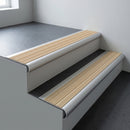 Aluminium bullnose stair nosing 66.5x30mm with Porth Stone Castellated insert fitted on an office stair