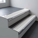 Polished aluminium bullnose stair nosing 66.5x30mm with White Castellated insert fitted on an office stair